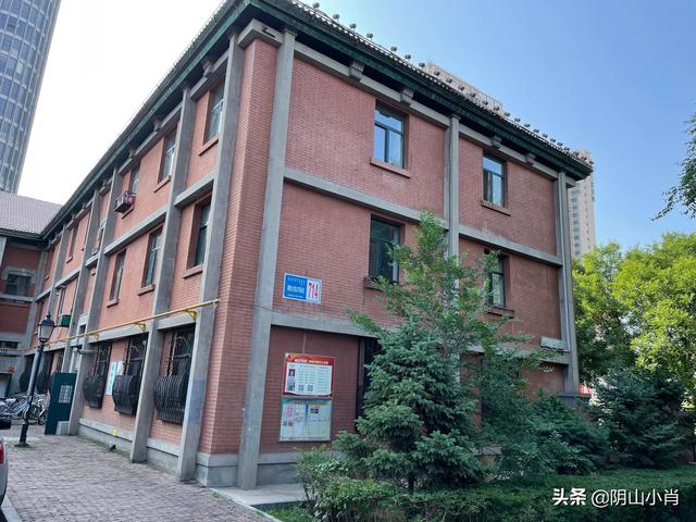 钢32街坊一栋红砖楼的底层墙面，白色门牌标注"钢铁大街714"。这个地址本身说明街坊和钢铁大街的空间关系。