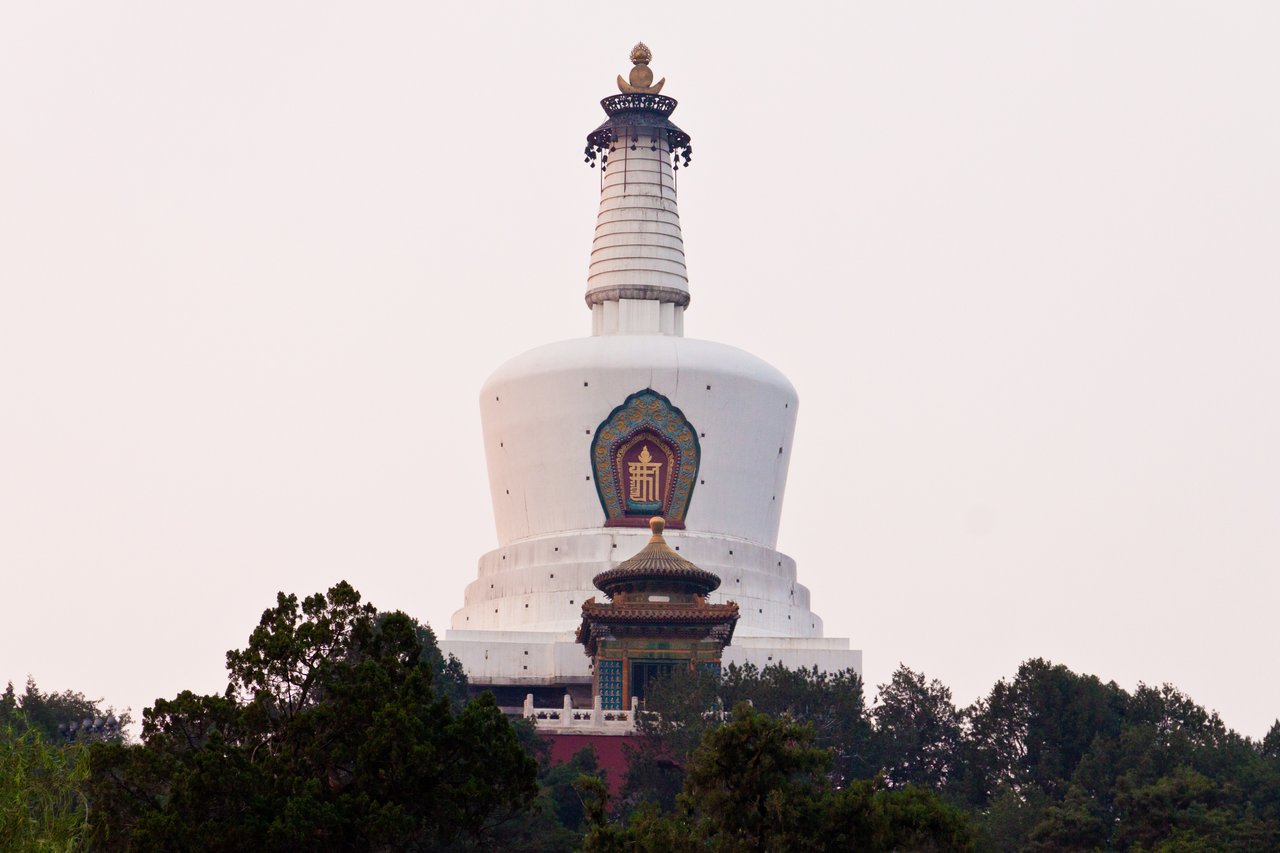 白塔从红墙和灰瓦后方升起，构成街区天际线