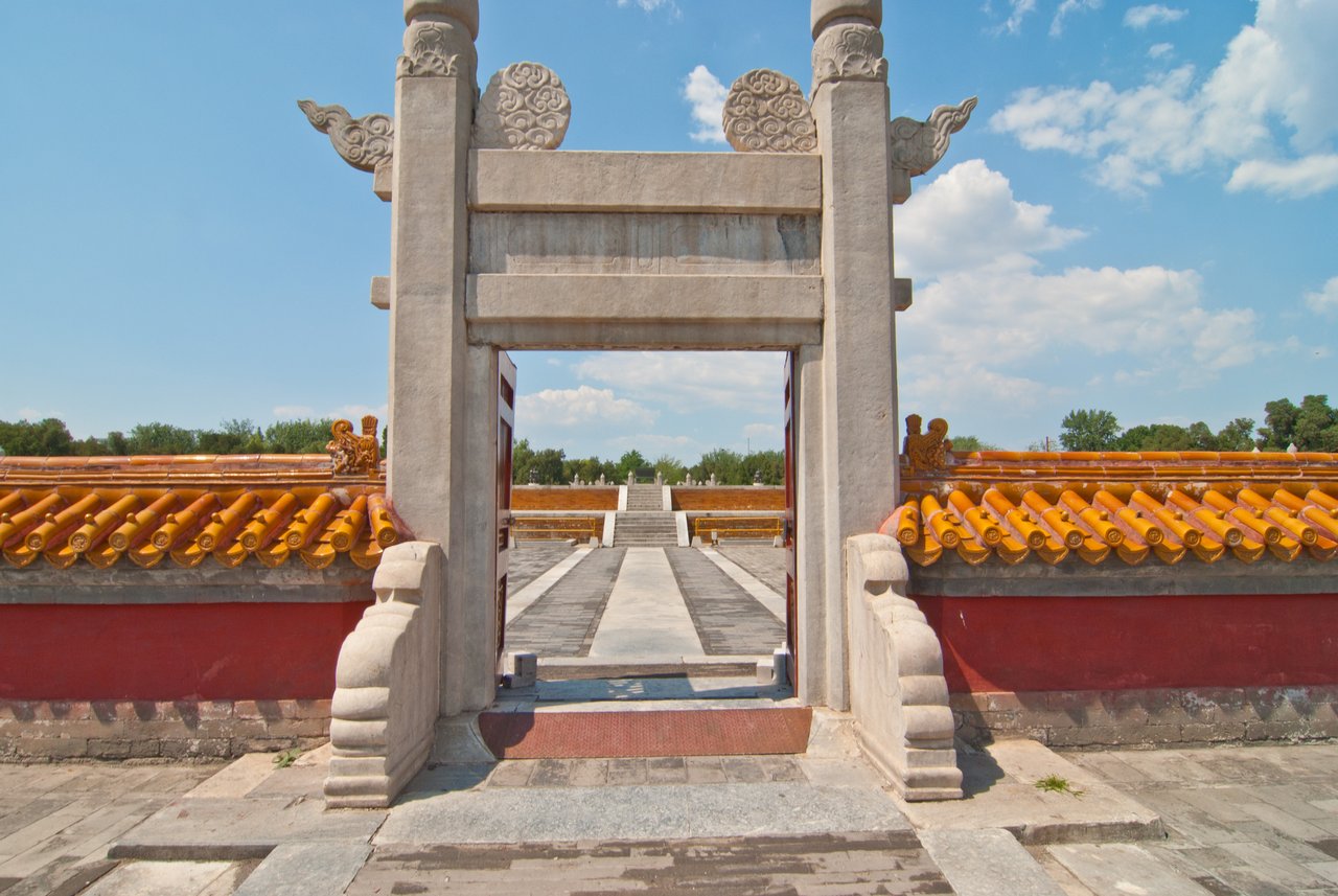 汉白玉棂星门正对方泽坛石阶，画面同时框出黄琉璃坛墙顶：方坛与黄瓦两个核心要素同框