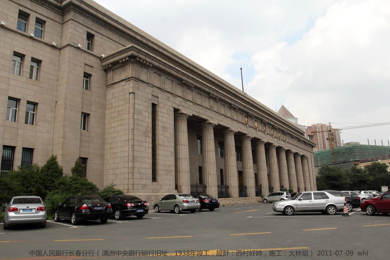 伪满中央银行旧址正立面，十根多立克石柱支撑的门廊上方悬挂中国人民银行标志