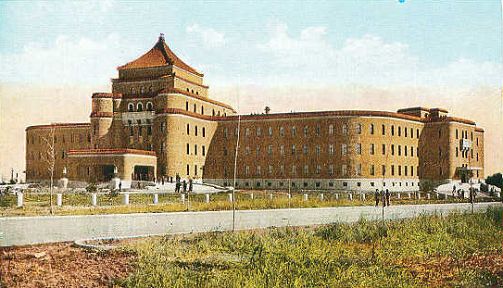 伪满综合法衙旧址全景：紫红色塔楼、弧线外墙、咖啡色贴面