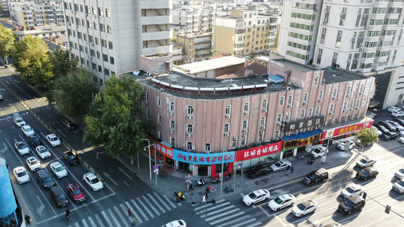 建筑转角弧面和纵向线条外观，底部可见商业橱窗