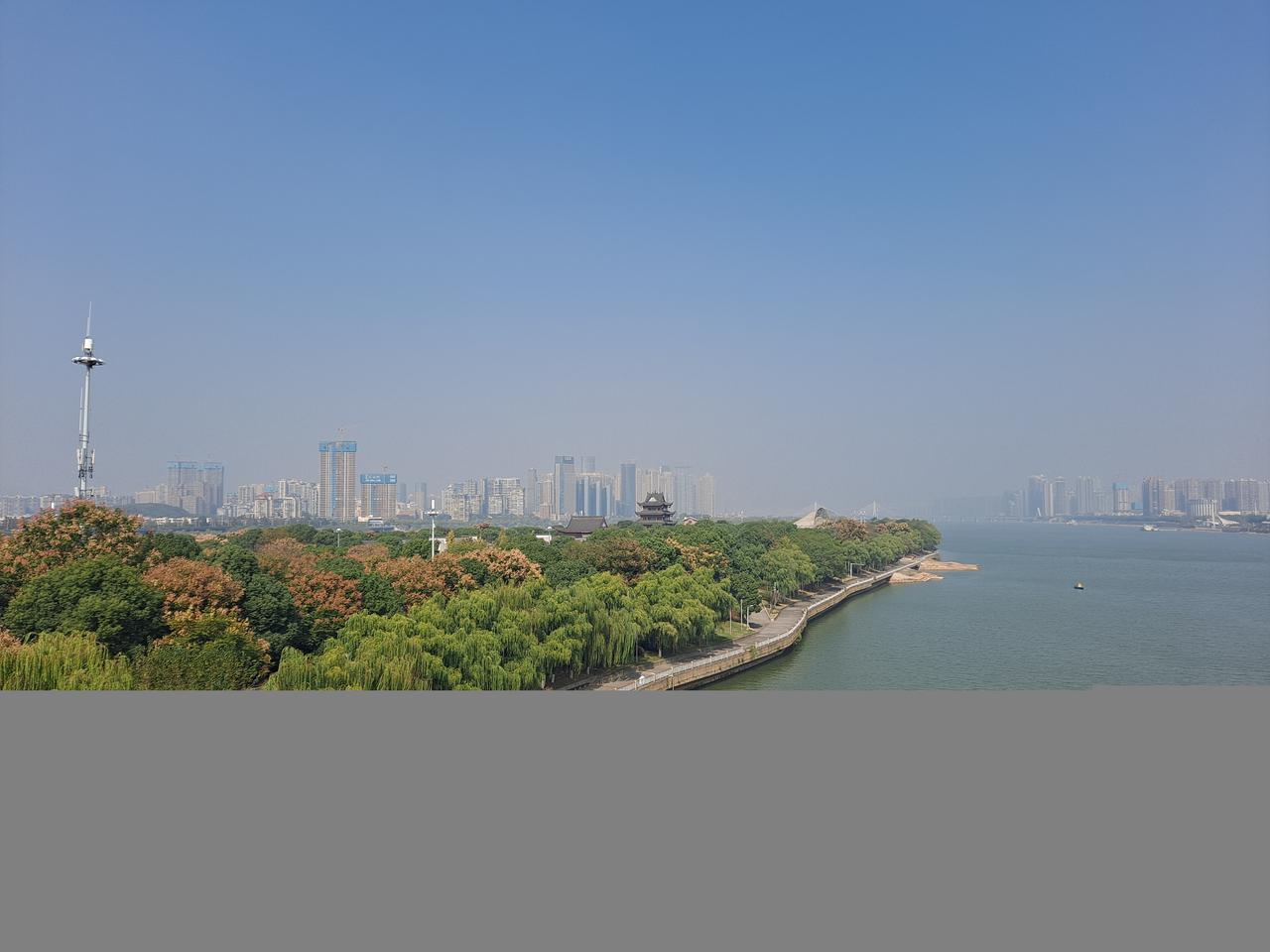 从湘江西岸看橘子洲，狭长沙洲夹在两岸城市之间
