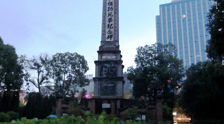 A tall monument with Chinese inscriptions stands prominently