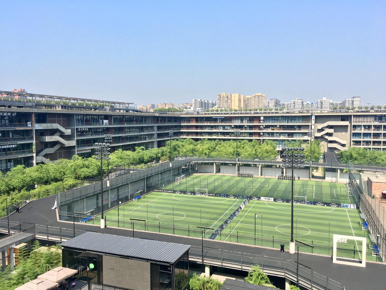 西村大院中央庭院内景，竹林环绕足球场和公共活动区