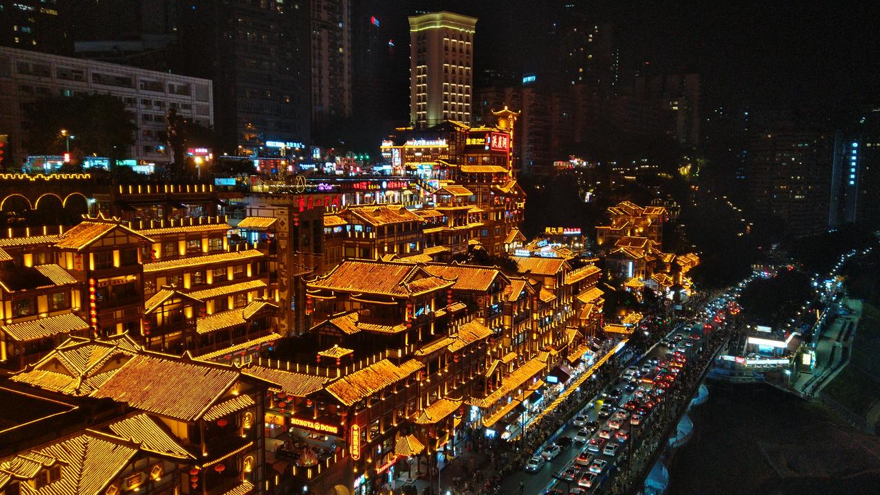从千厮门大桥看洪崖洞和嘉滨路，崖壁上的传统建筑和崖底的道路形成垂直对照