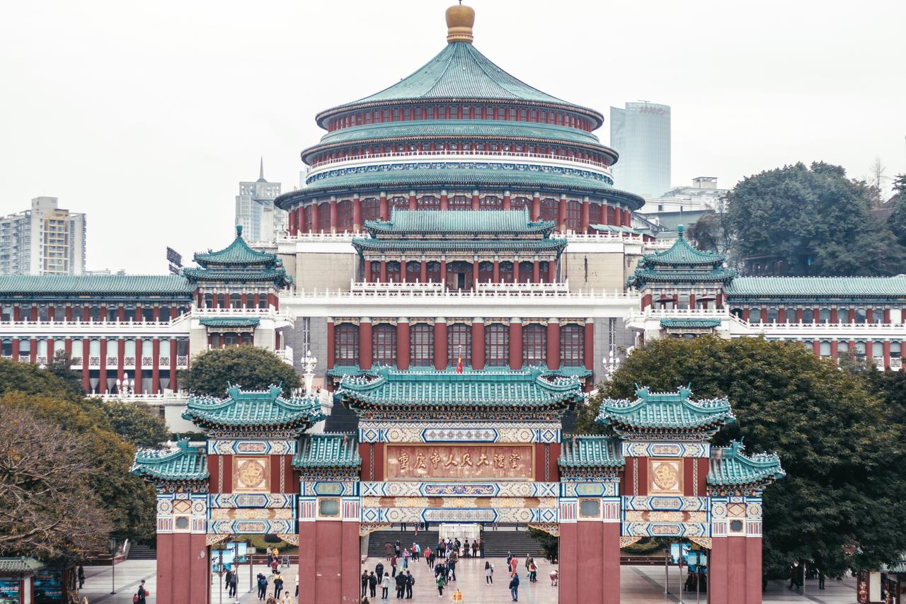 从人民广场看人民大礼堂正面，蓝色琉璃瓦穹顶在重庆阴天背景下极为显眼