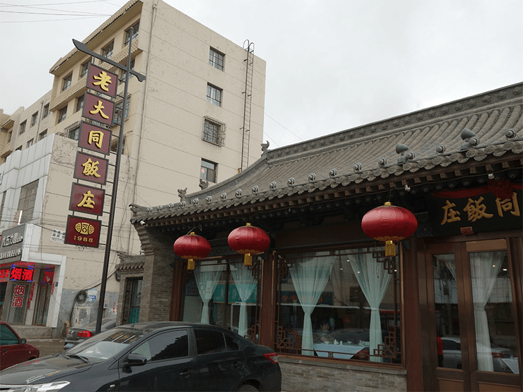 鼓楼东街的茶室与传统民居门面，红灯笼与青砖灰瓦构成街道的主要视觉元素。图源：China Wonders Guide。
