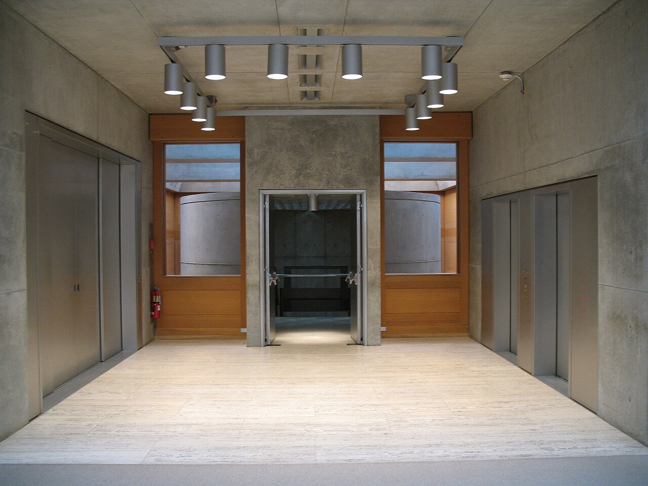 An interior court with travertine, white oak, concrete, and daylight