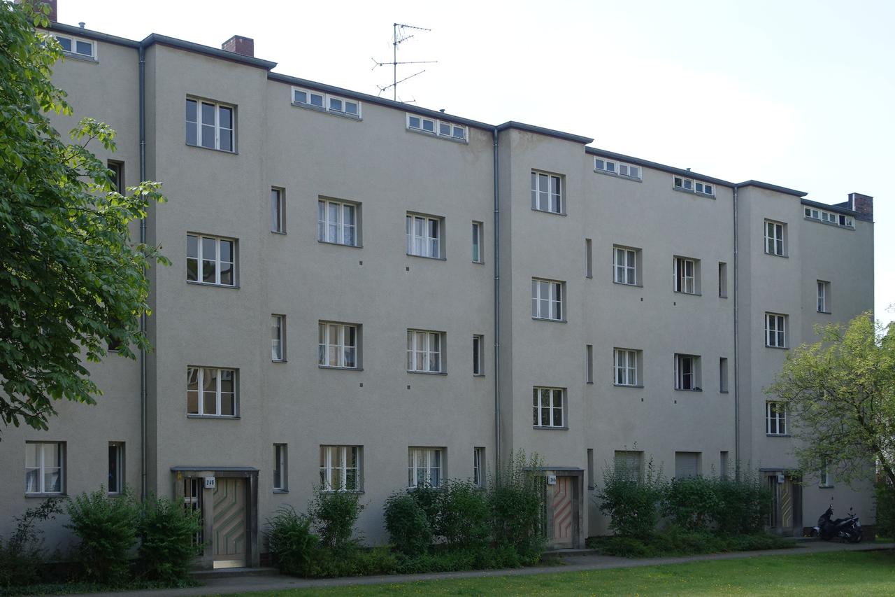 Buschkrugallee 的 Zeilenbau 线性建筑，红砖与浅色立面的标准 Taut 风格