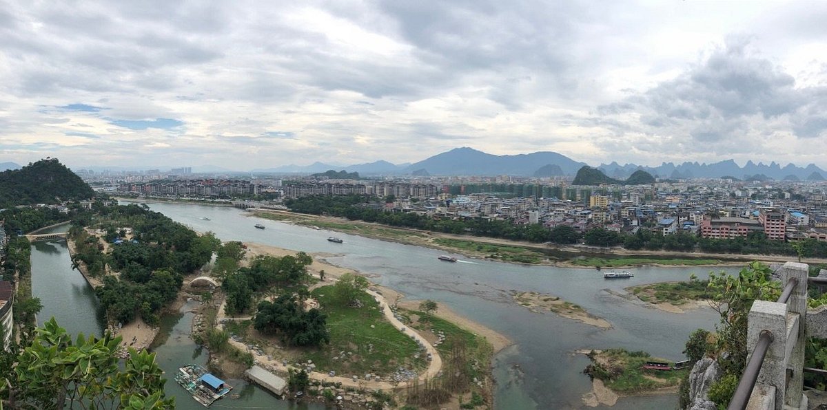 漓江从叠彩山区域蜿蜒流过，两岸喀斯特峰林倒映水中