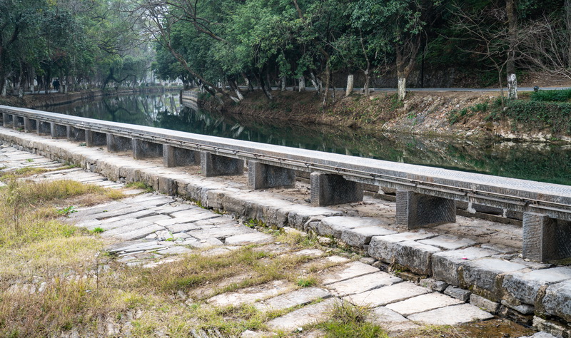 灵渠南渠沿岸风光，渠道蜿蜒穿过丘陵农田，两岸植被葱郁