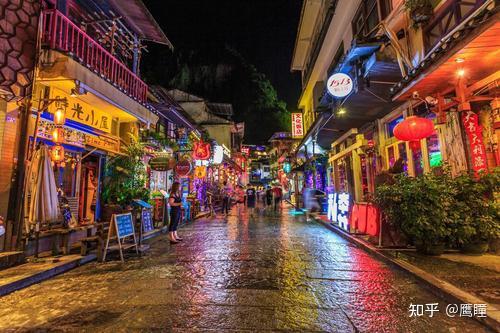 阳朔西街白天街景，桂北传统建筑与中西融合的商业招牌并置