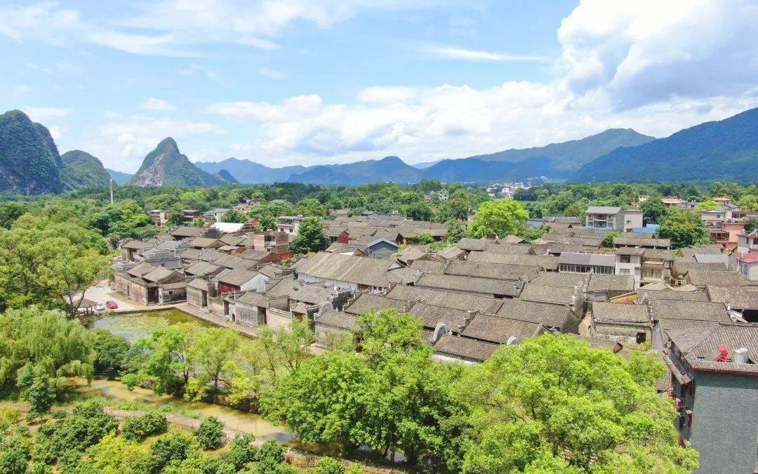 江头村航拍全景，青砖灰瓦的明清民居群落在喀斯特地貌的背景下展开