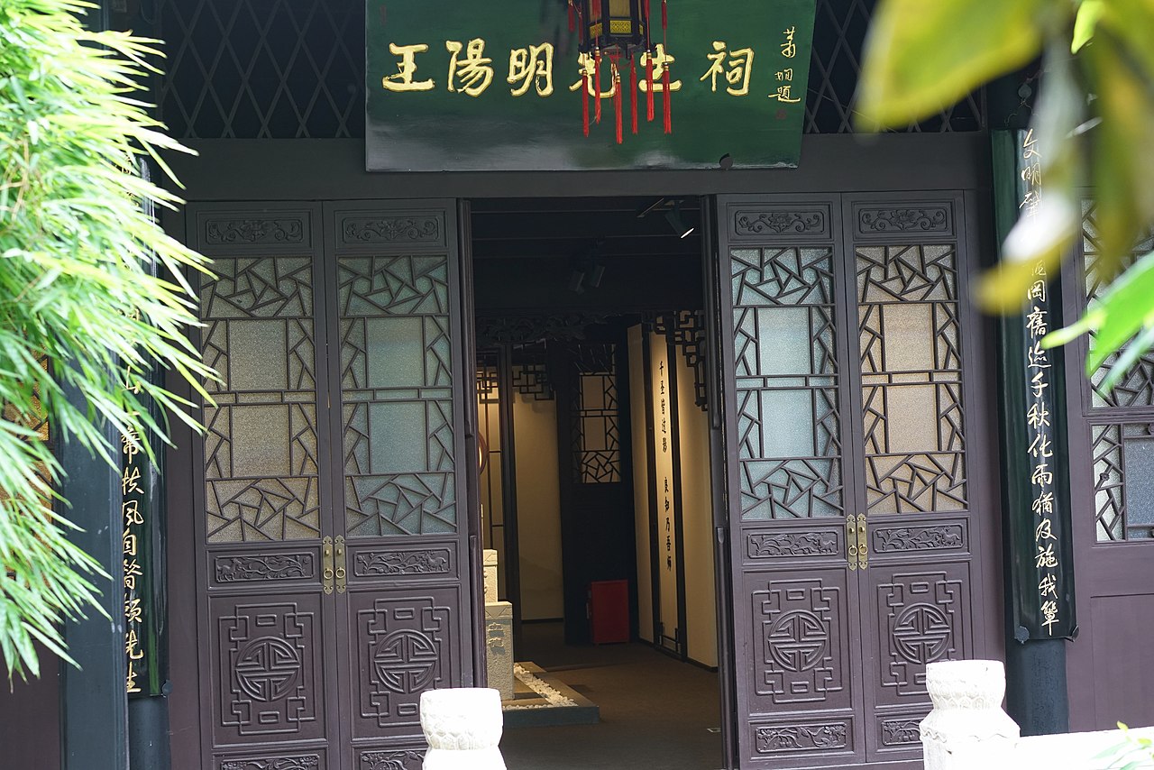 阳明祠享堂外观，单檐青瓦建筑与扶风山环境