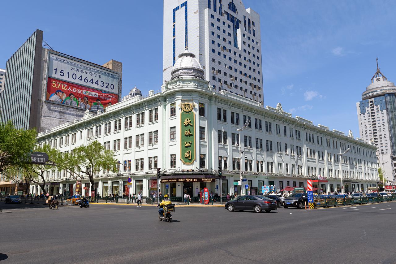 秋林公司建筑外景，转角处银色穹顶与灰绿色墙体