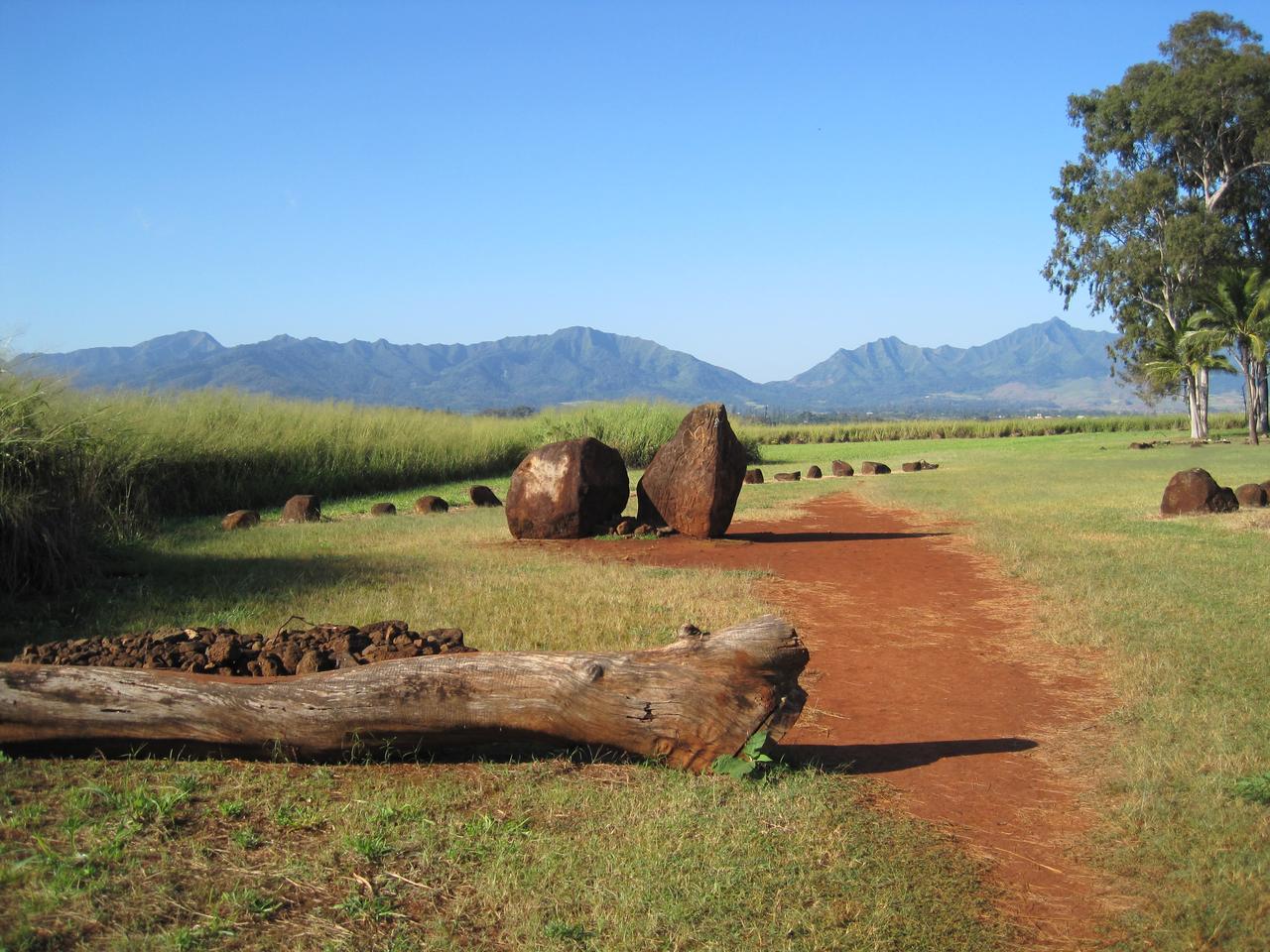 从入口方向看 Kūkaniloko 场地，背景是 Kolekole Pass 和 Waiʻanae 山脉的轮廓