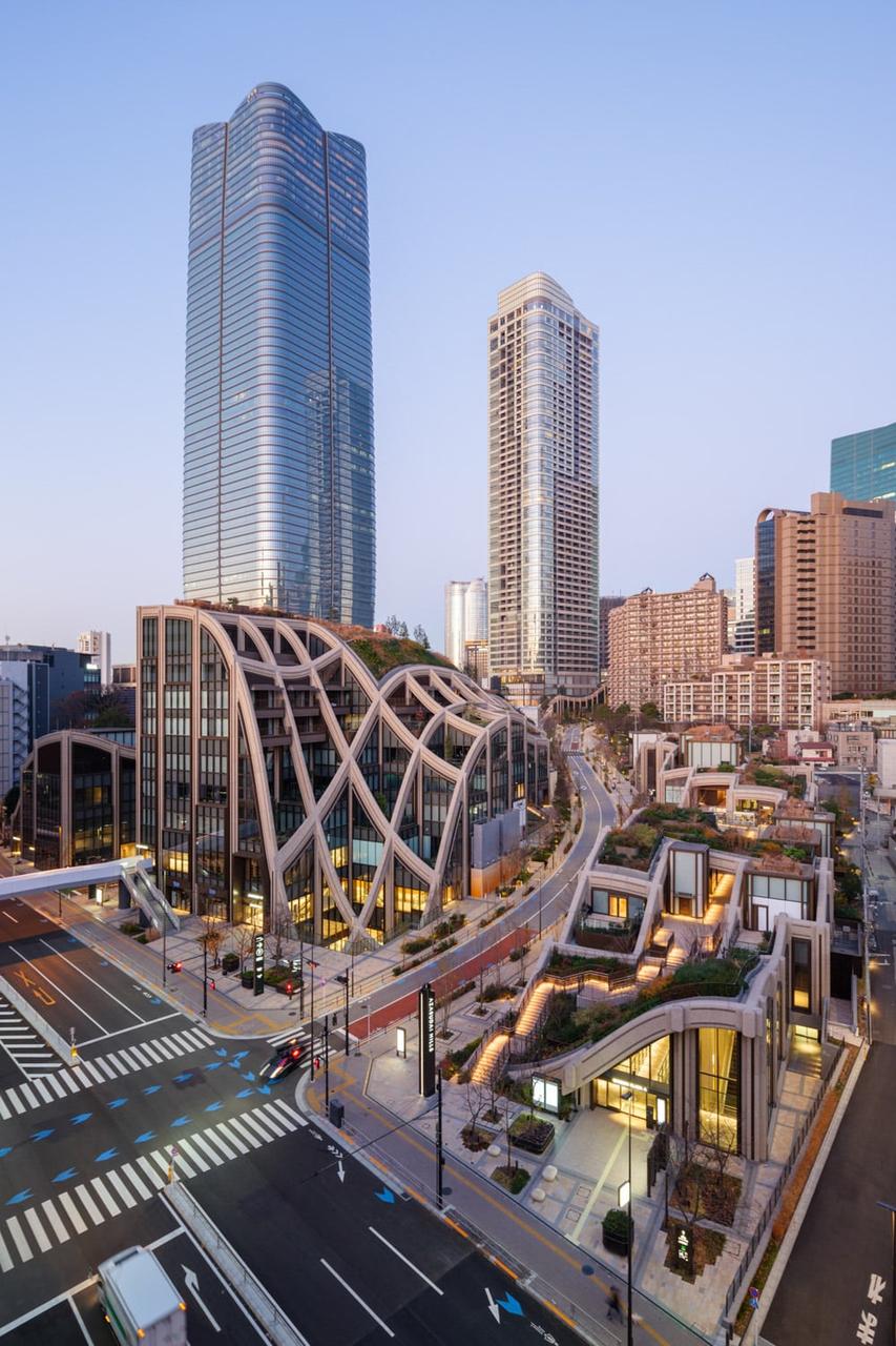 中央广场绿地及 Heatherwick Studio 设计的低层建筑，背景为 Mori JP Tower