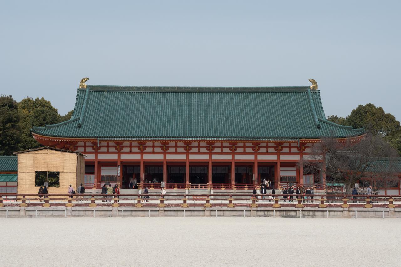 大极殿正面全景，朱红柱廊、绿瓦屋顶和白砂中庭左右对称展开