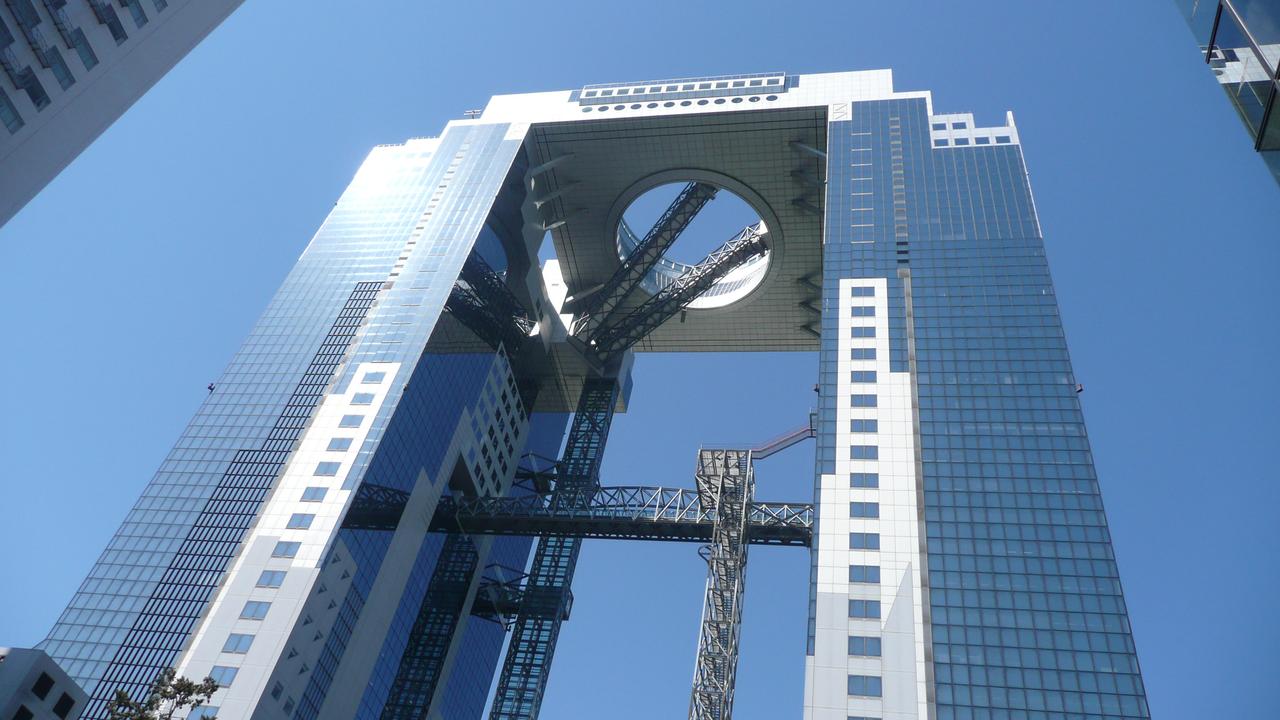 从大阪站方向看向梅田蓝天大厦，在周边现代高层建筑中的天际线轮廓