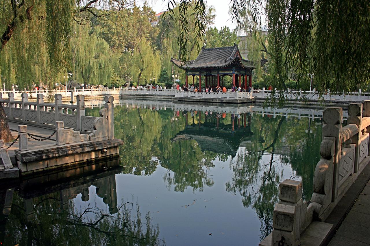 泉池全景，汉白玉栏杆环绕，远处浮玑亭探入水面