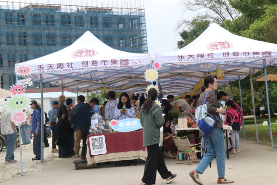 乐天陶社创意市集现场，白色帐篷摊位沿厂区空地排开