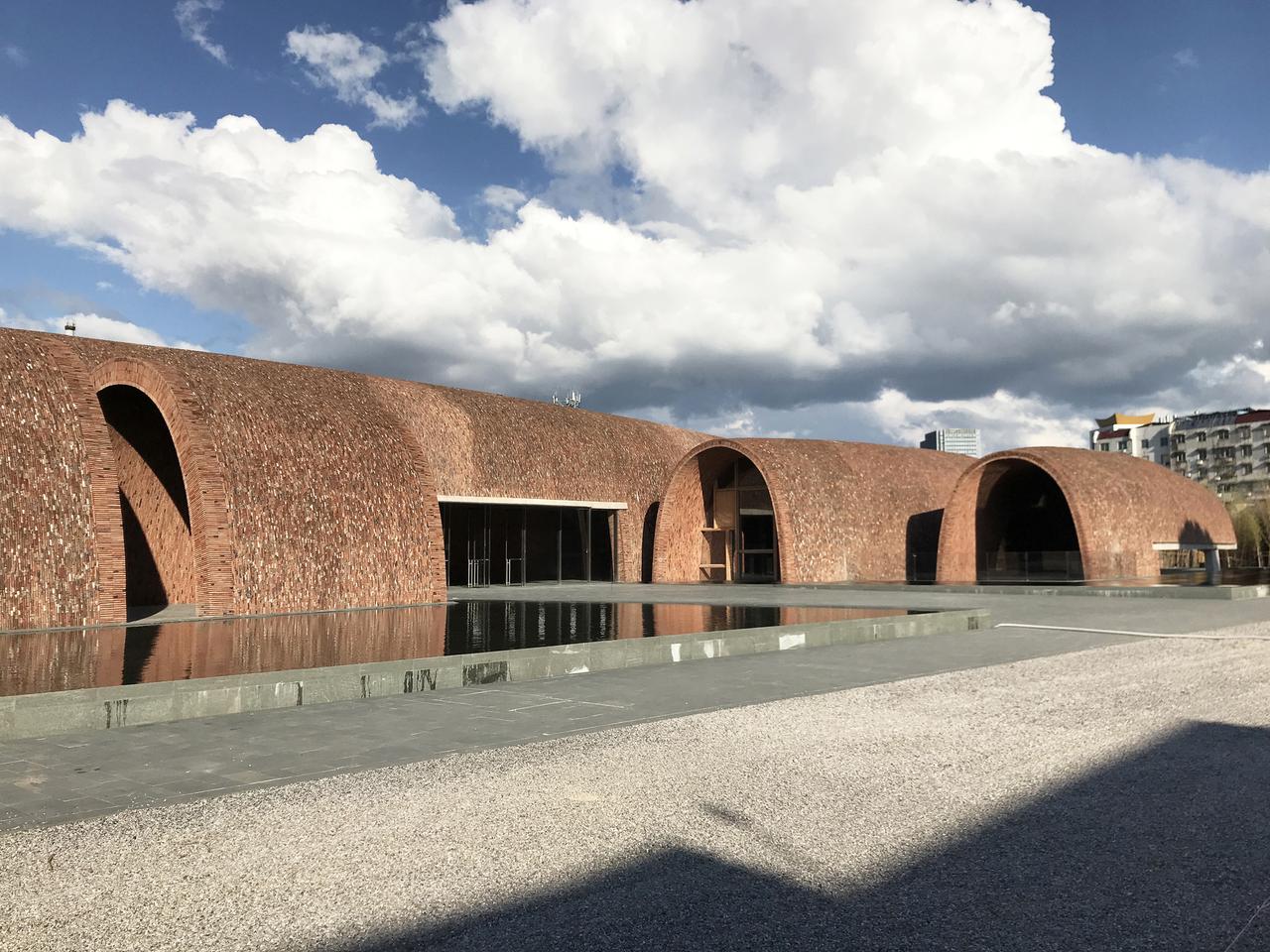 御窑博物馆建筑外观，八个砖拱体沿南北轴向排列，前方有浅水池