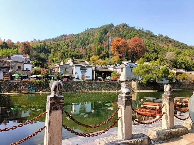 瑶河沿岸的古镇风貌，远处青山与近处徽派建筑倒映在清澈河水中
