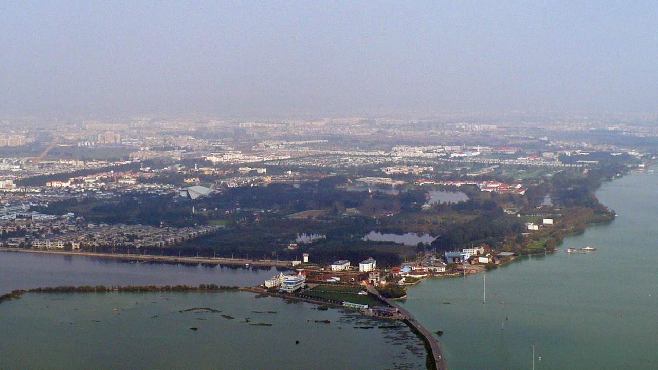 从西山远眺滇池，水面、城市和远山在同一个画面里