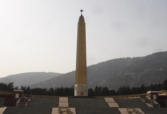 An obelisk with a star at the top stands prominently, set against a backdrop of 