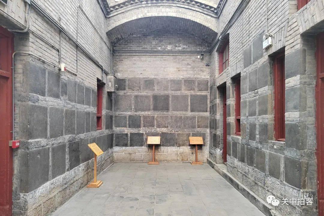 千唐志斋窑洞展厅内景，墙壁上嵌满历代墓志铭石刻