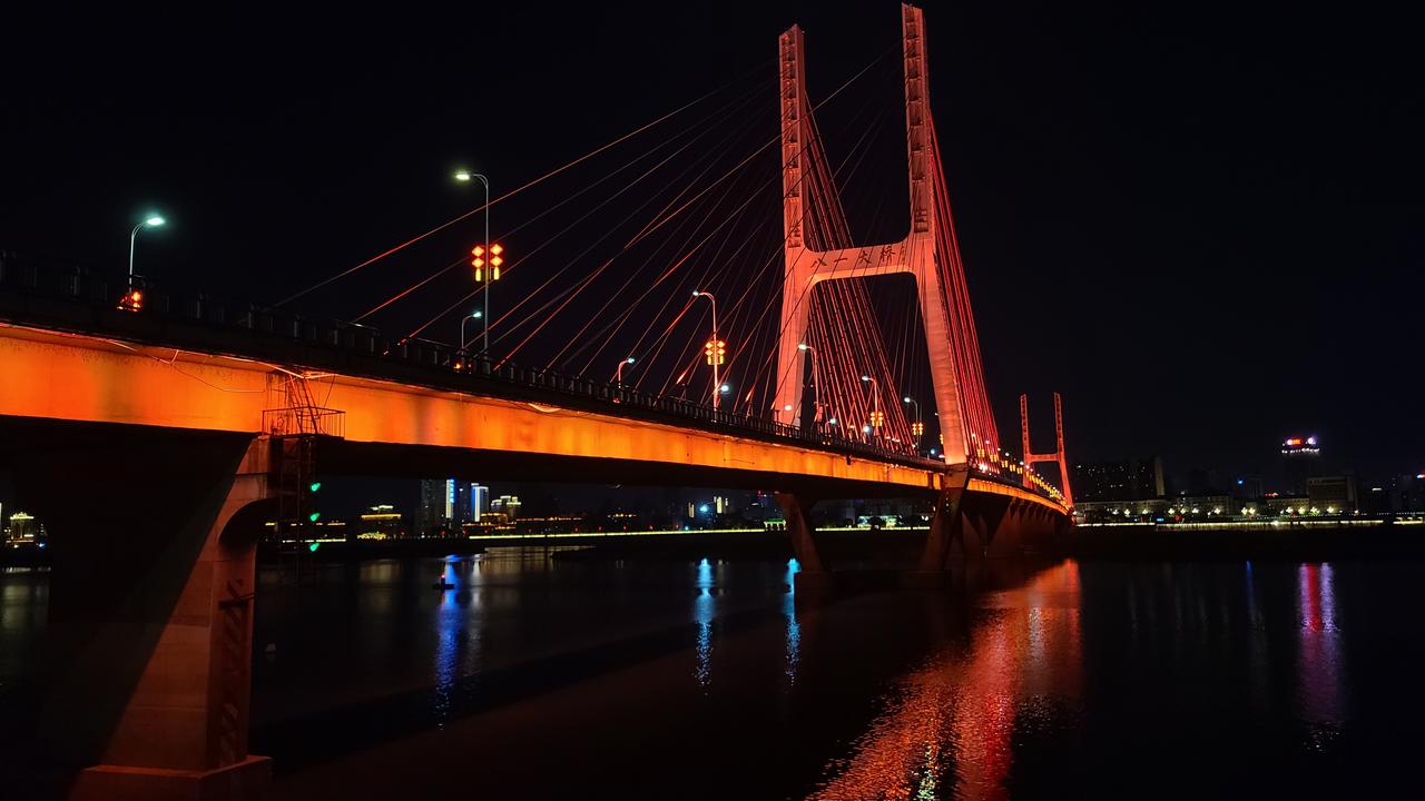 八一大桥夜景，斜拉索和桥塔在灯光中倒映在赣江水面