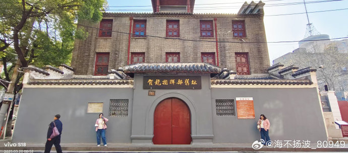 朱德旧居大门近景，可见青砖墙和文物保护标志牌