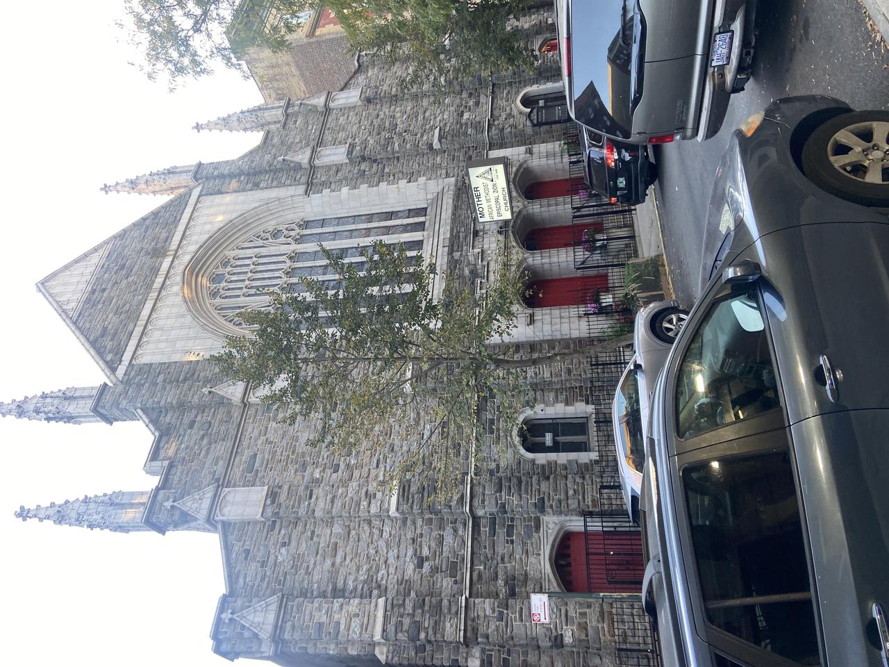 Mother AME Zion Church 侧前方视角，显示全立面、尖塔和 street-level 入口