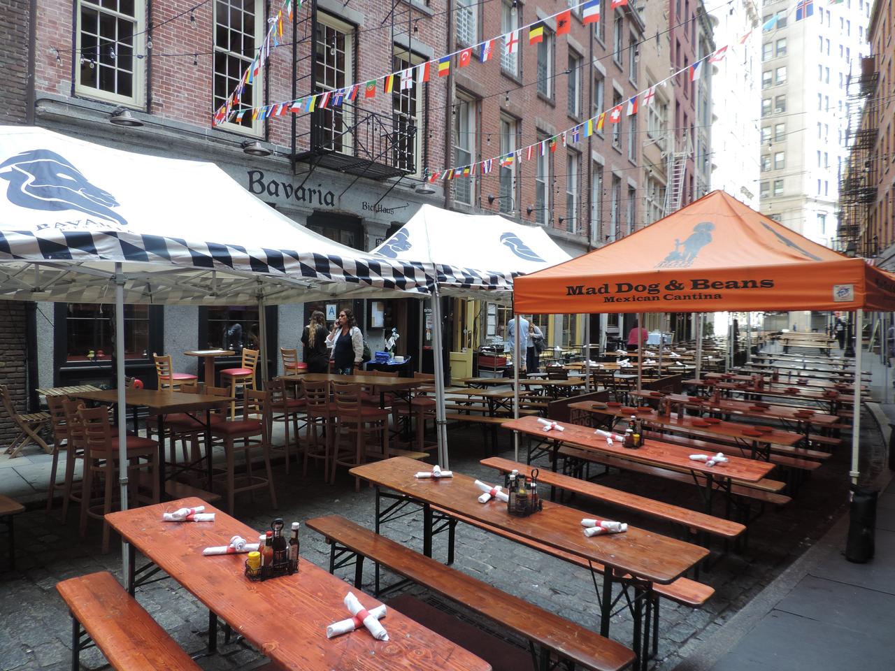 Stone Street 户外餐饮和串灯，左侧砖楼和右侧现代大厦形成对比