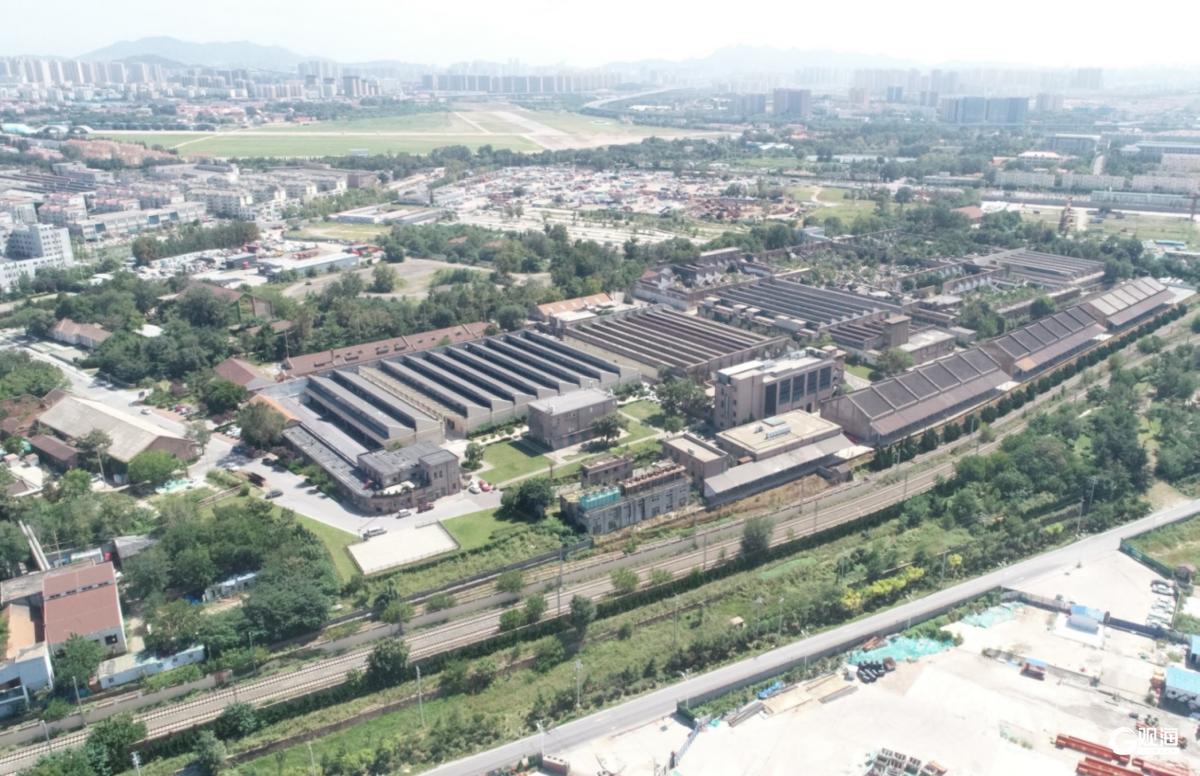 国棉六厂厂区鸟瞰，锯齿形厂房和铁路专用线清晰可见，展示工业建筑的大尺度布局