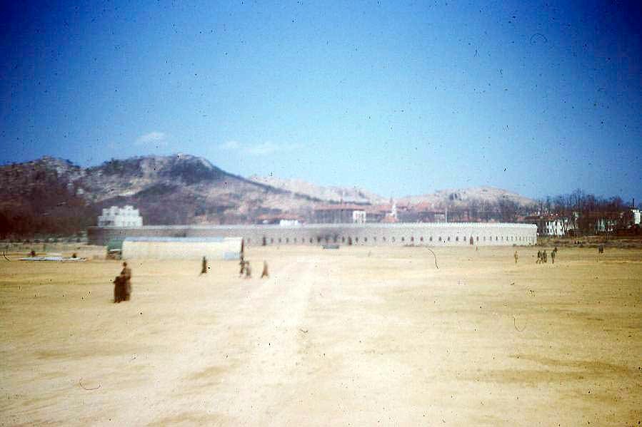 1940 年代美军航拍汇泉跑马场，椭圆形跑道轮廓完整，东侧是青岛第一体育场