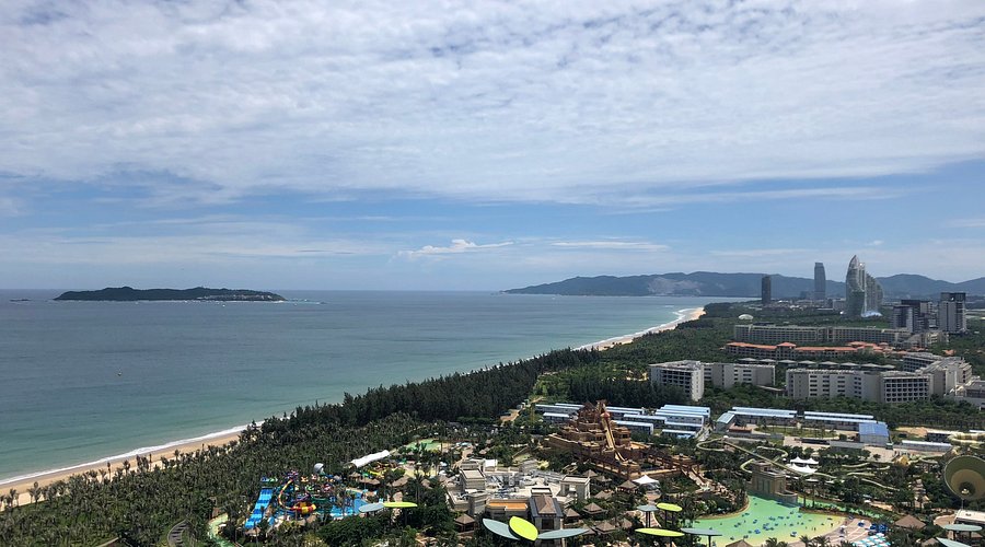 海棠湾海岸线全景，沙滩与海水在晴天下颜色分明