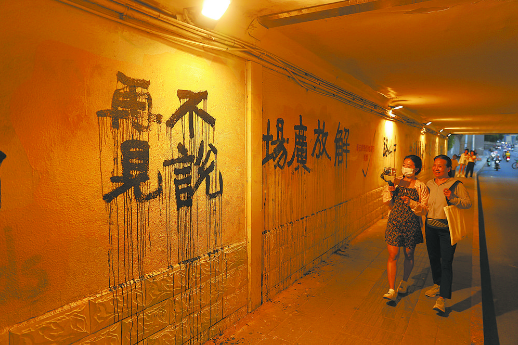 铁路入地后中山路地道桥原址填平，行人走过已消失的铁路切割线