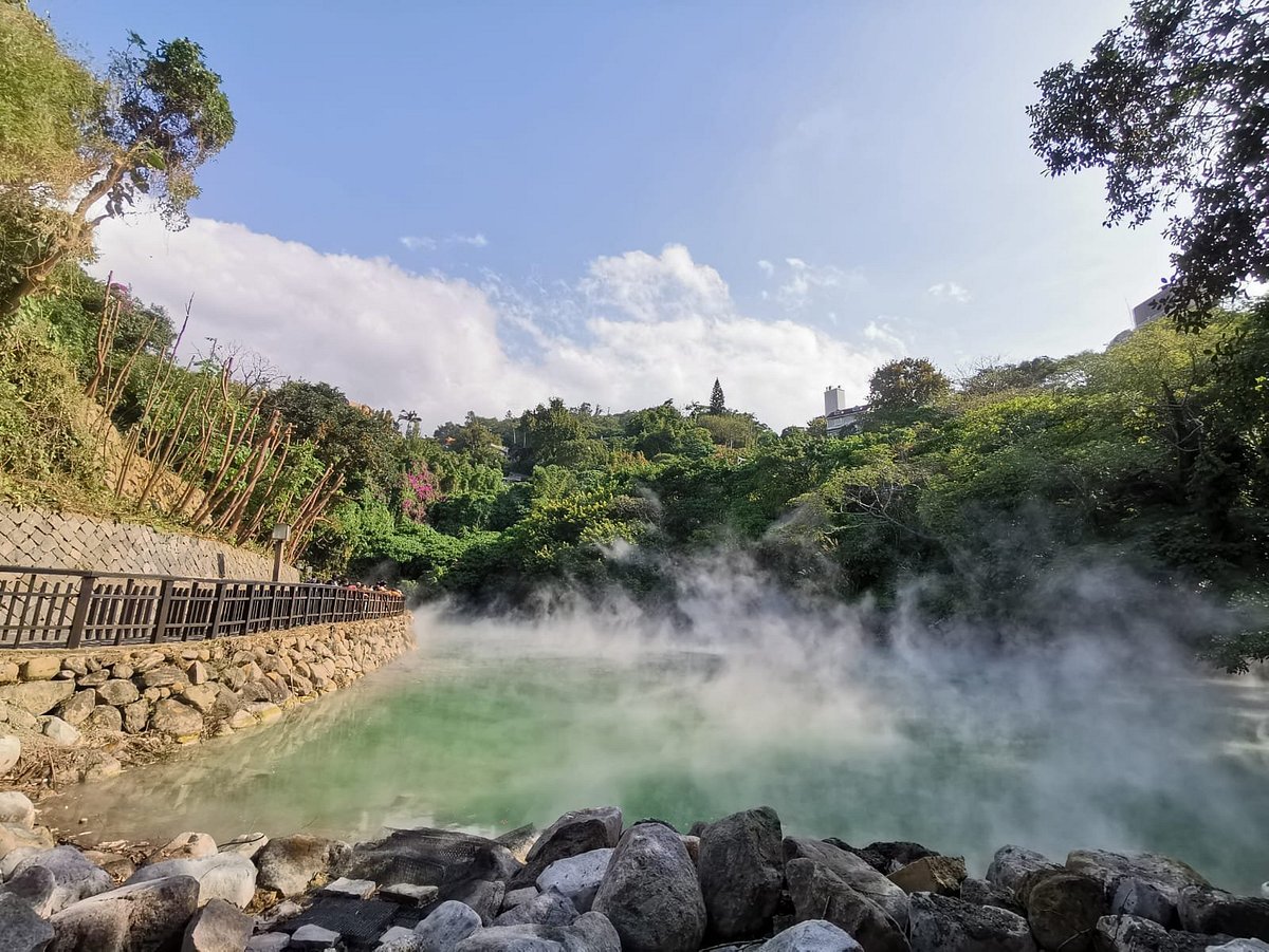 The image shows the hot spring at Beitou Thermal Valley with steam rising from t