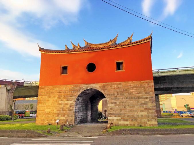 A traditional Chinese-style gate with a red wall and curved roof is situated at 