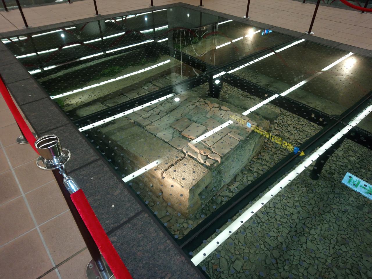 北门站玻璃地板展示坑，下方可见清代机器局石板路和墙基
