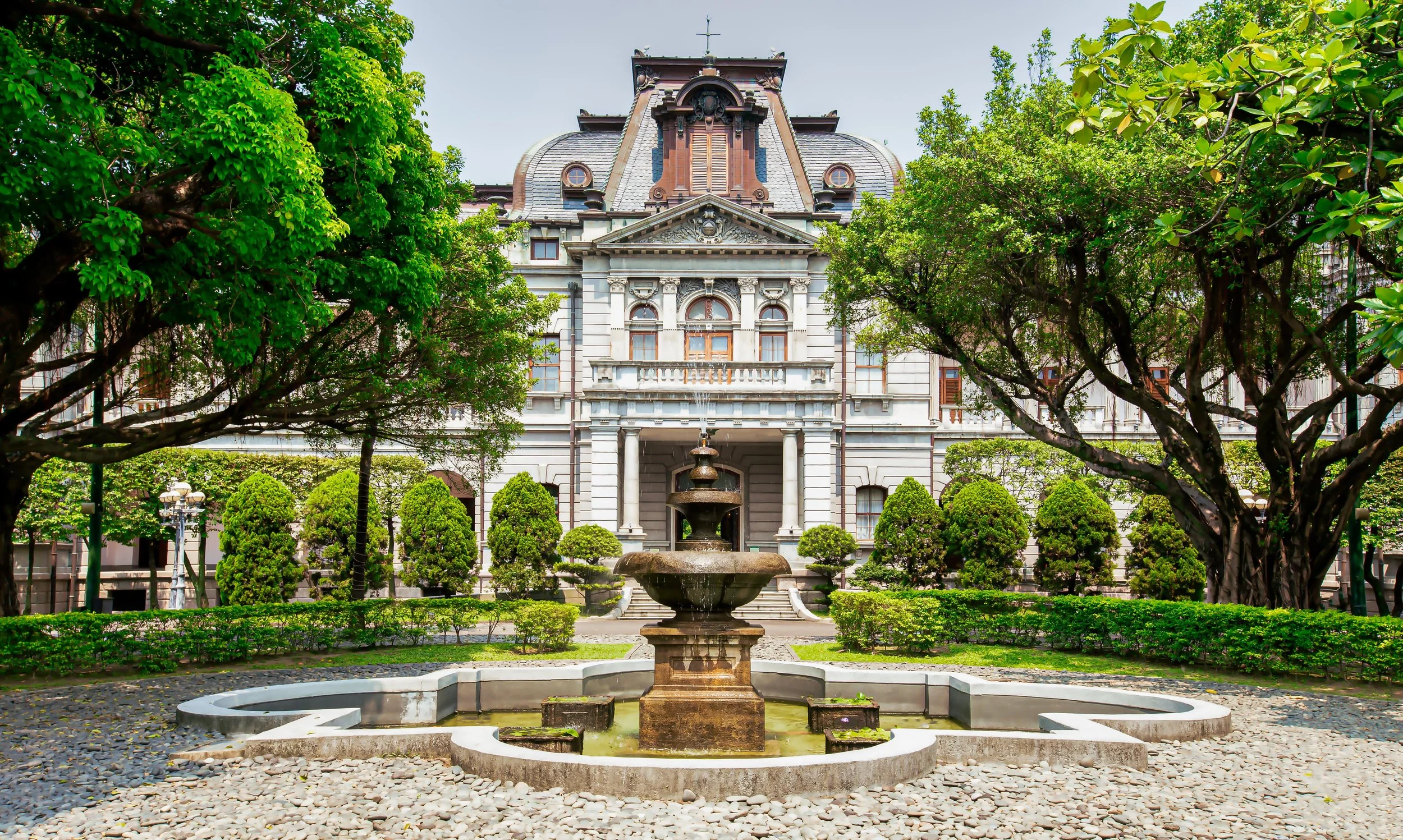 A historic building with classical architecture, featuring white stone walls, co