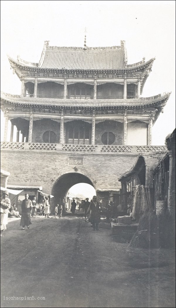 清末迪化城东门城楼老照片，可见两层城楼和沿街集市