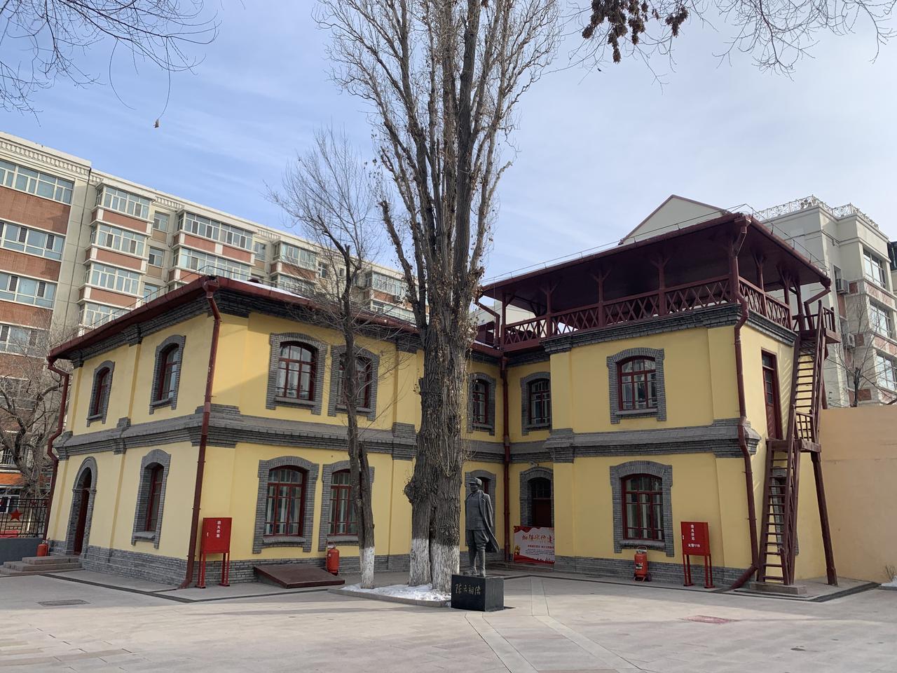 八路军驻新疆办事处旧址外观，黄色二层小楼，青砖砌腰，红色铁皮屋顶