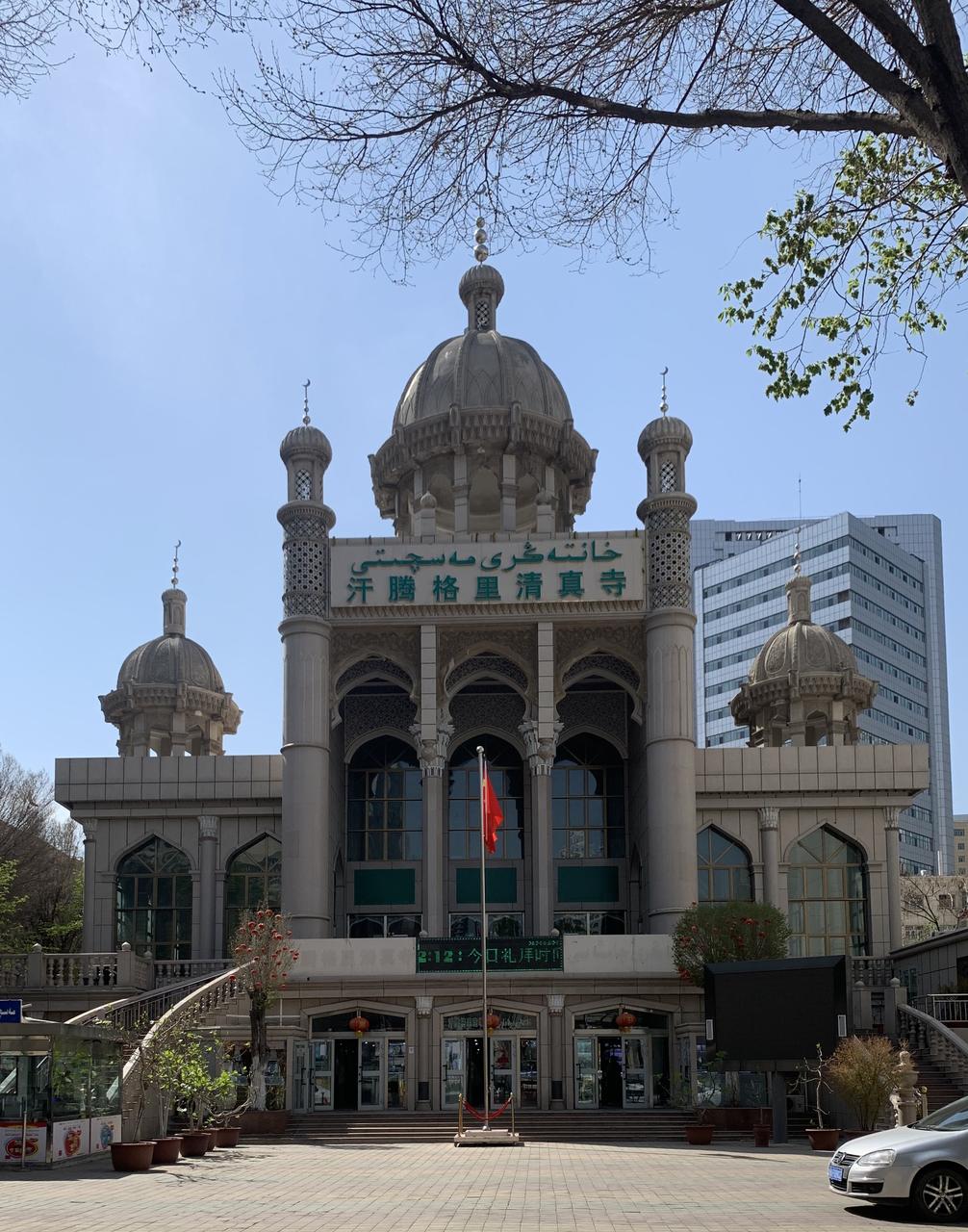 汗腾格里清真寺南立面，绿色穹顶从解放南路商业建筑轮廓线上方升起
