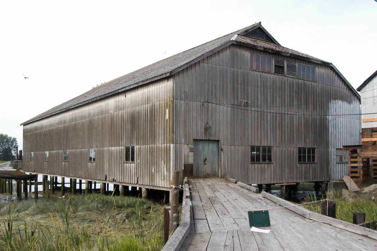 Britannia Shipyards 全景，Fraser River 岸边排列的桩基木建筑群，栈道连接各栋
