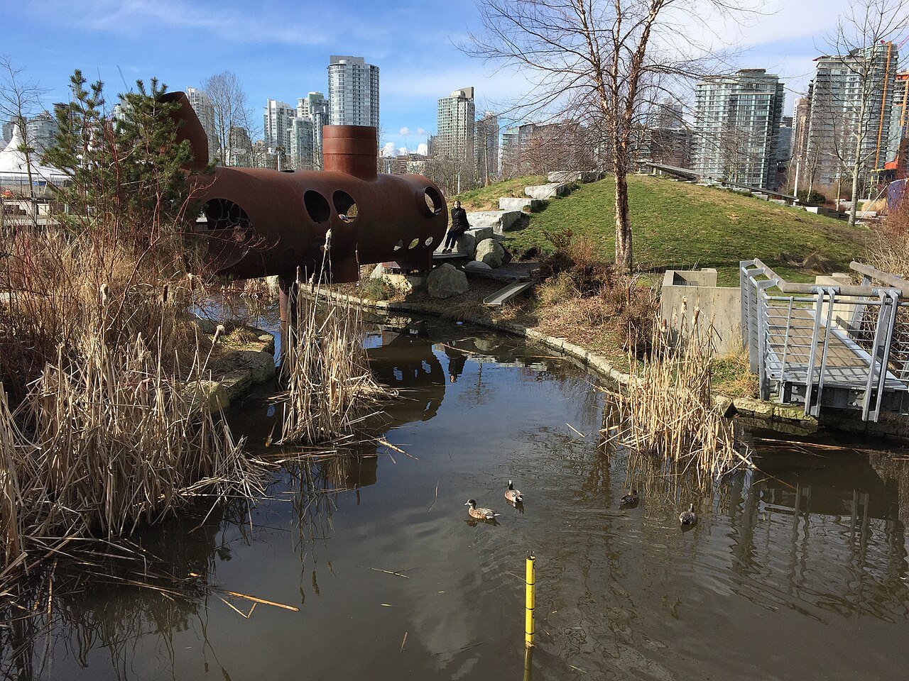 Hinge Park 的 Hollow Tube 钢管桥横跨梯级湿地，芦苇和水道清晰可见