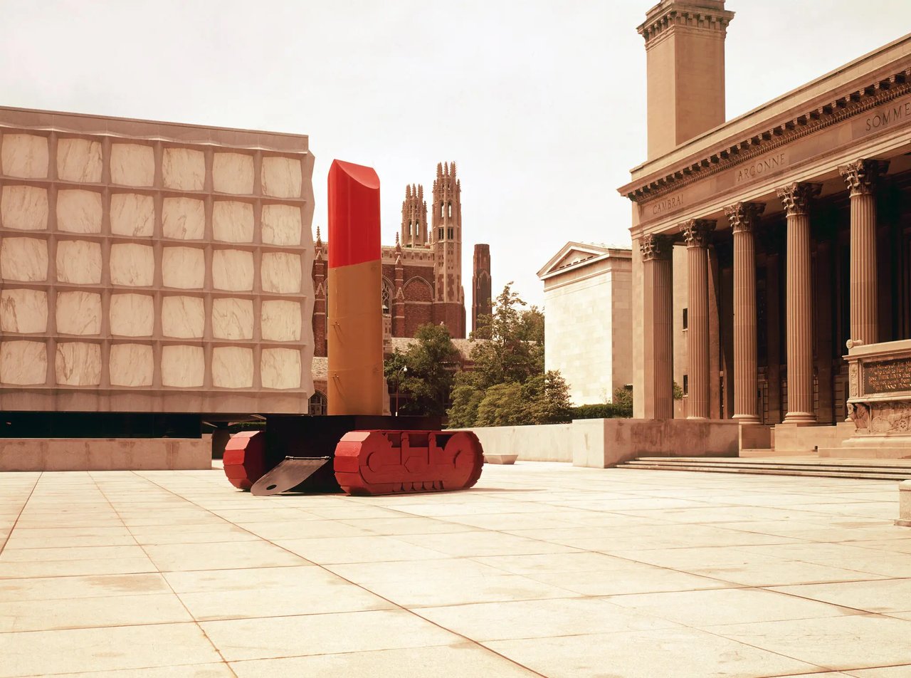 Lipstick (Ascending) on Caterpillar Tracks by Claes Oldenburg, a red lipstick form rising diagonally from black tank treads