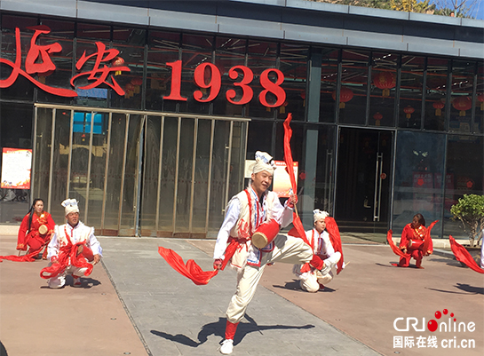 安塞腰鼓表演者在延安1938街区广场上演出，背景建筑可见"延安 1938"字样